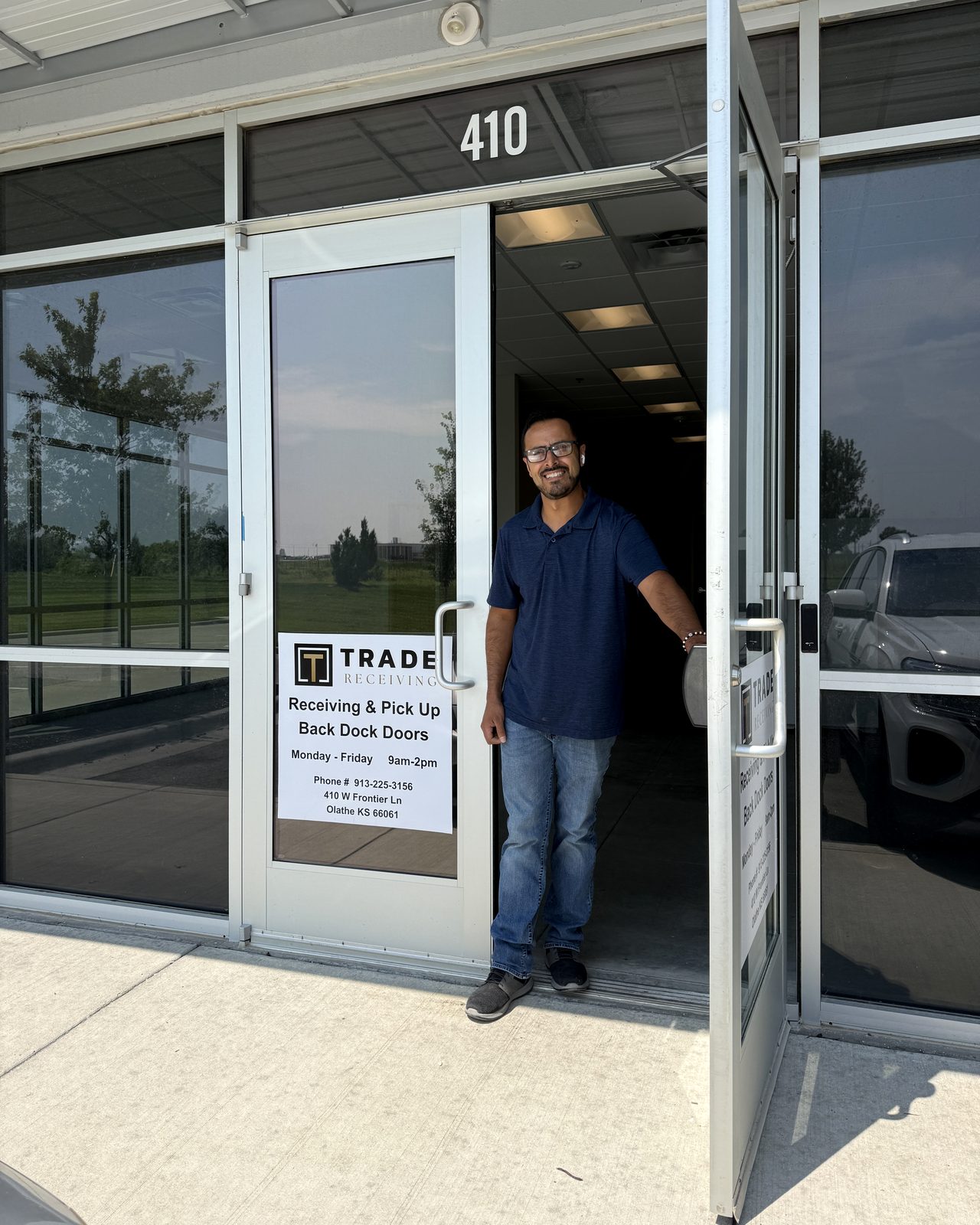 A Trade Receiving team member holding open the front door at 410 W Frontier Lane in Olathe