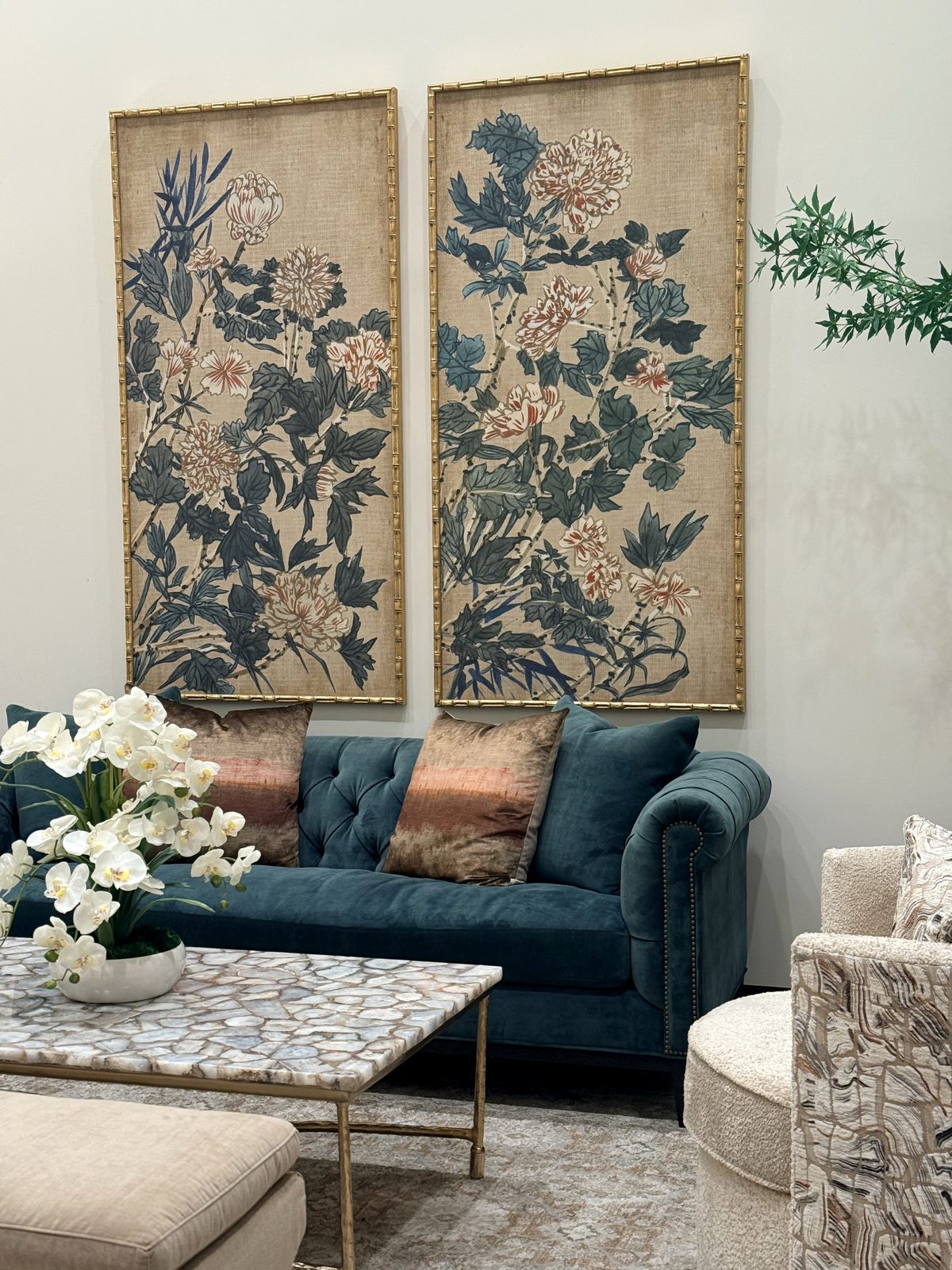 A finished installation: framed art panels above a styled sofa and seating vignette